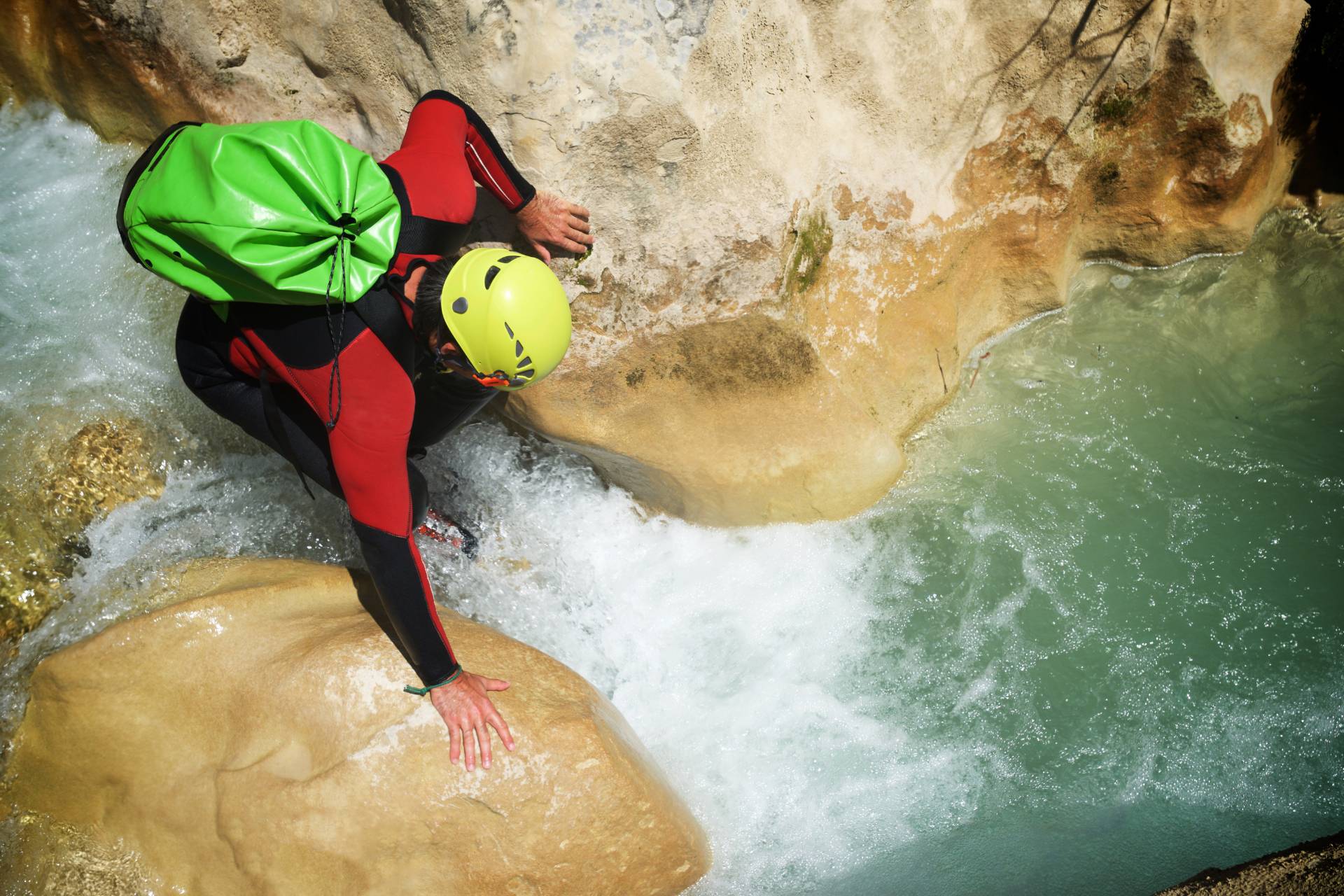 Descente de canyon à La Réunion Canyonneur franchissant un passage rocheux dans l’eau vive à La Réunion
