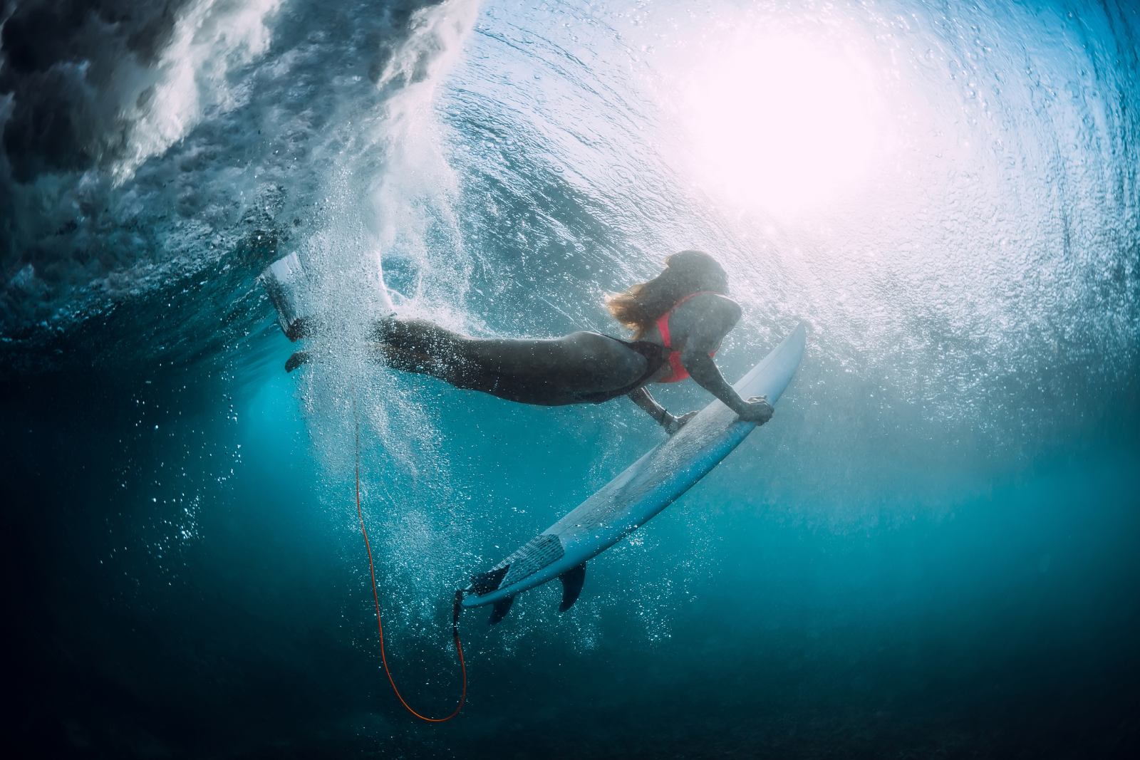 Duck dive sous une vague à La Réunion Surfeuse réalisant un duck dive sous une vague dans l’eau claire de La Réunion