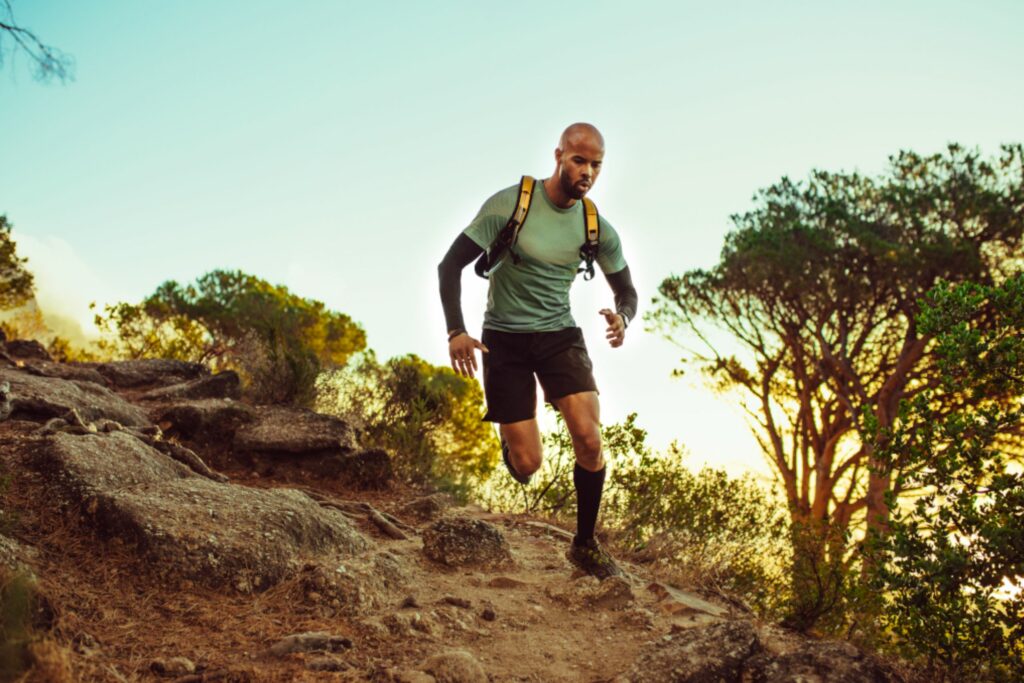 Coureurs traversant les montagnes du Grand Raid de La Réunion avec le Piton de la Fournaise en arrière-plan