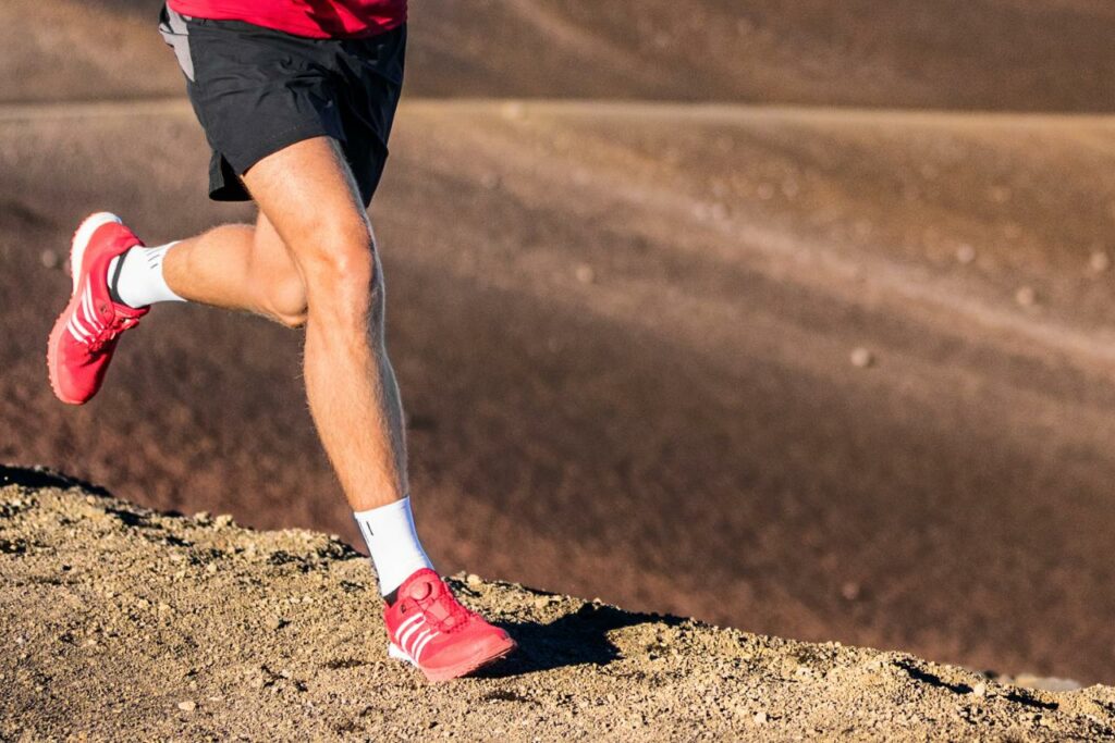 Coureurs traversant les montagnes du Grand Raid de La Réunion avec le Piton de la Fournaise en arrière-plan