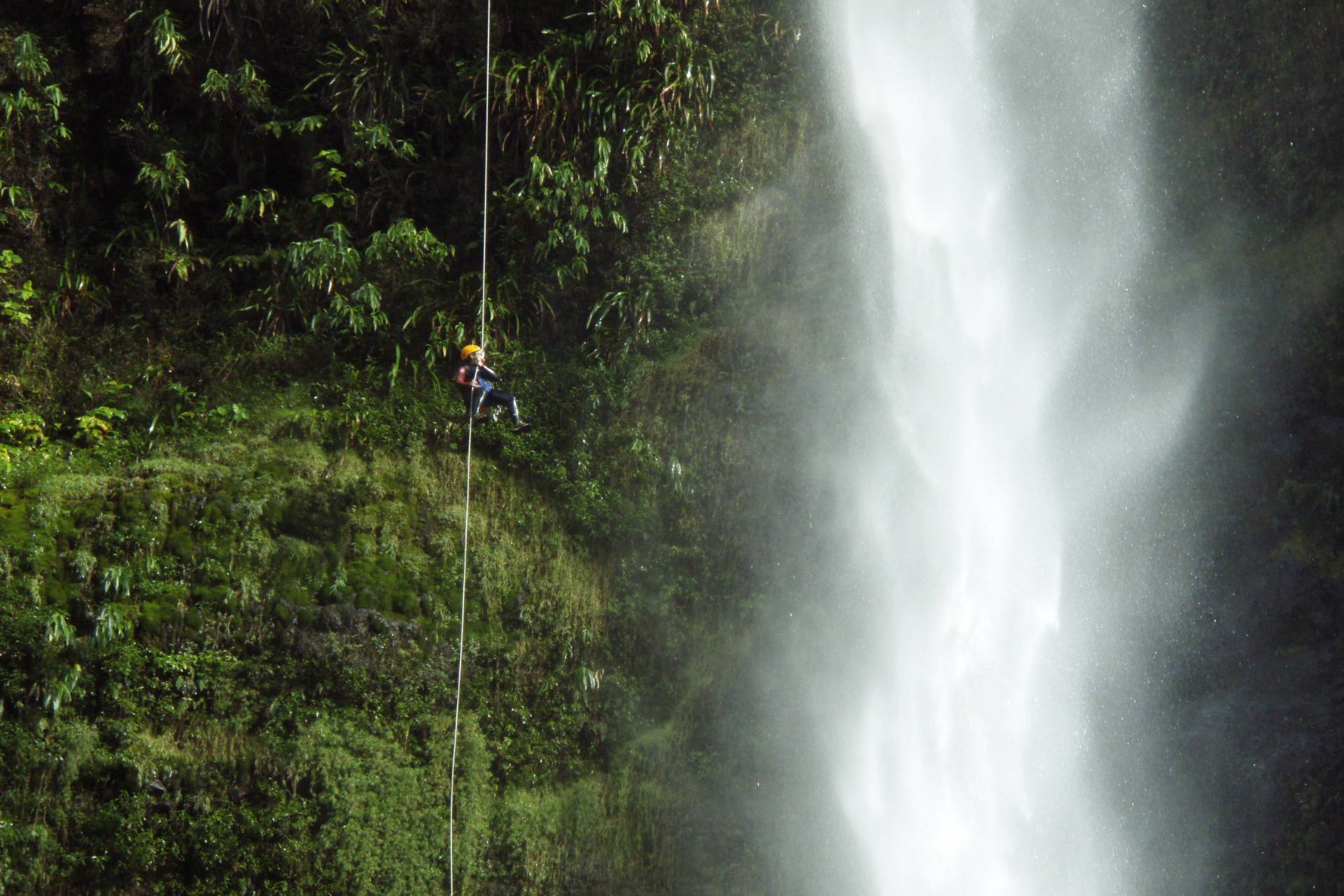 Canyoning Langevin à La Réunion Participant descendant en rappel le long d’une cascade à La Réunion