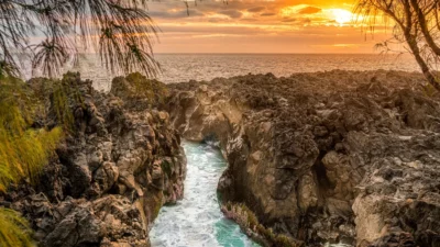 Le Gouffre d'Étang-Salé au coucher de soleil, une crevasse dans les roches volcaniques où les vagues de l'océan Indien s'engouffrent, île de La Réunion