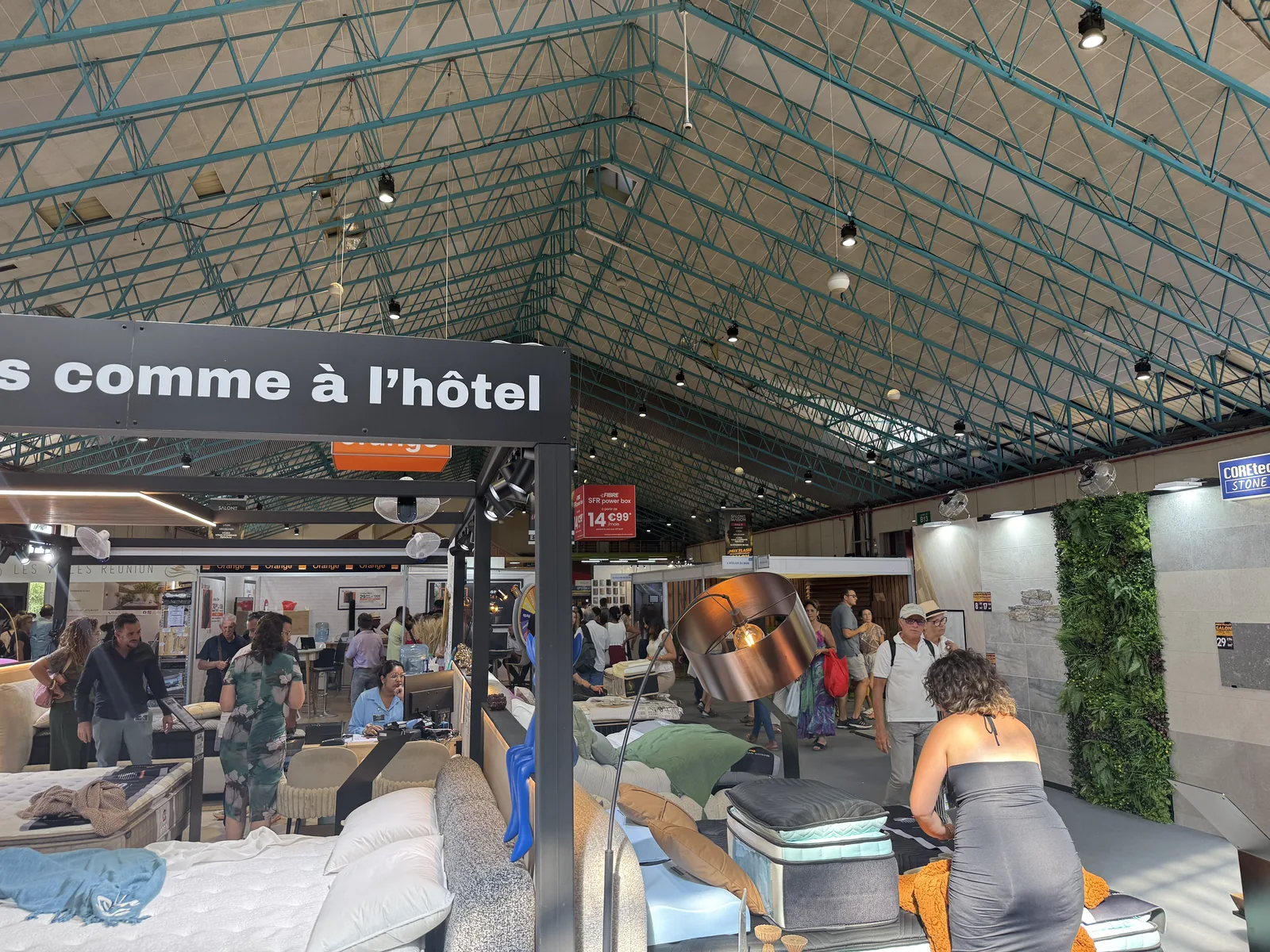 Stand de literie au Salon de la Maison 2026 mis en scène comme une chambre d'hôtel